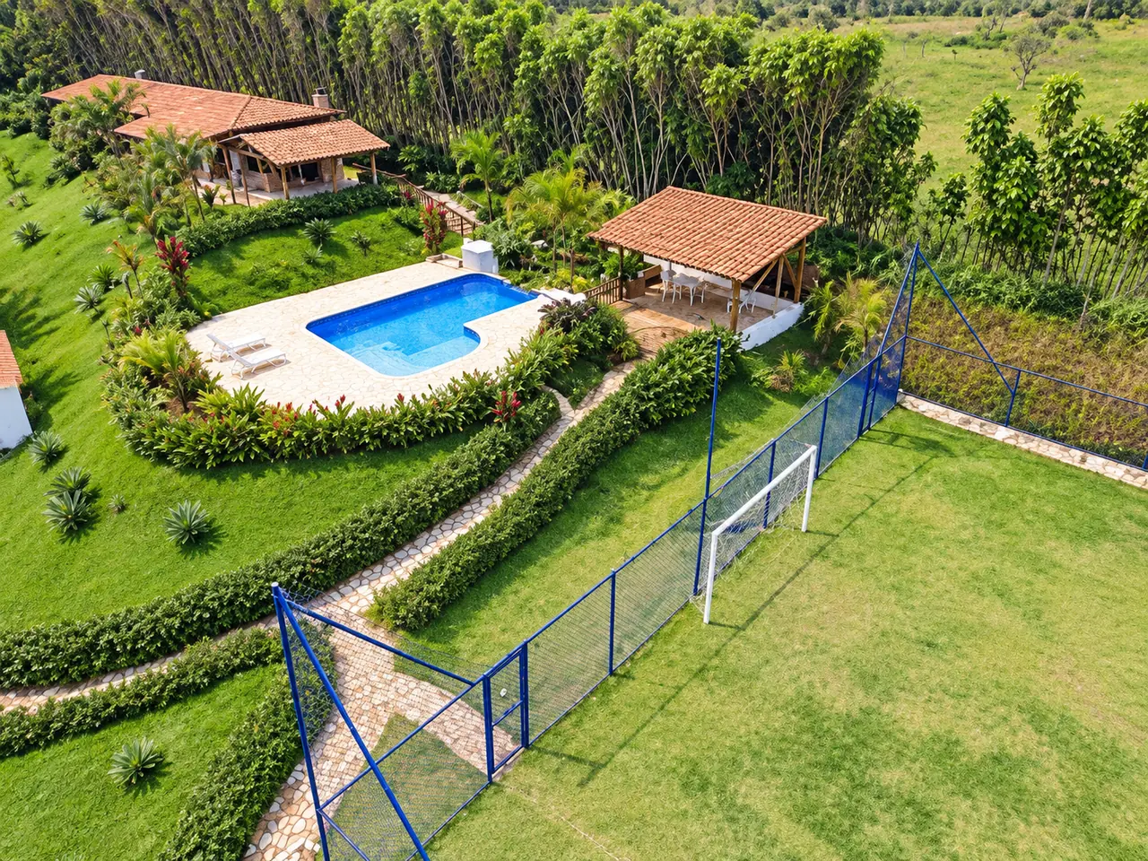 Vista aérea da Chácara Terracota mostrando a casa, a piscina, o quiosque e o campo de futebol